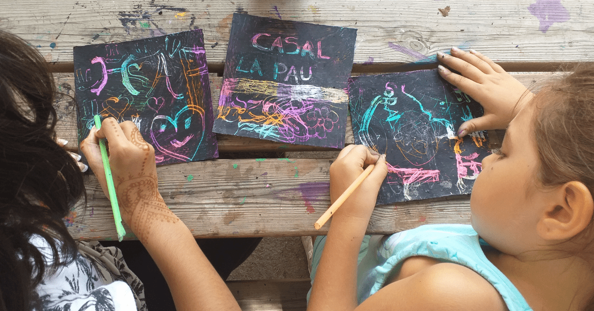 Niños y niñas dibujando en el Casal de verano de Fundació IRES