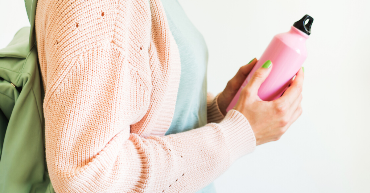 Dona amb ampolla reutilizable d'aigua